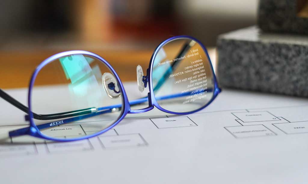 Image of reading glasses with CSS code reflecting in lense